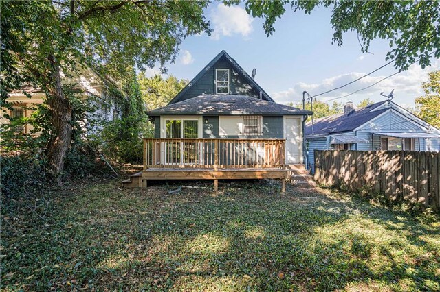 back of house featuring a wooden deck and a yard