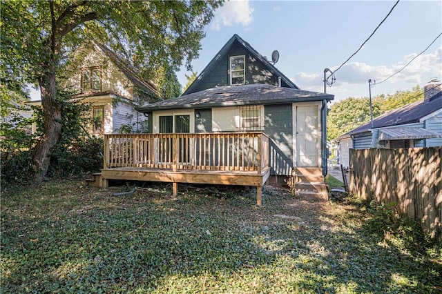 back of house featuring a deck and a lawn