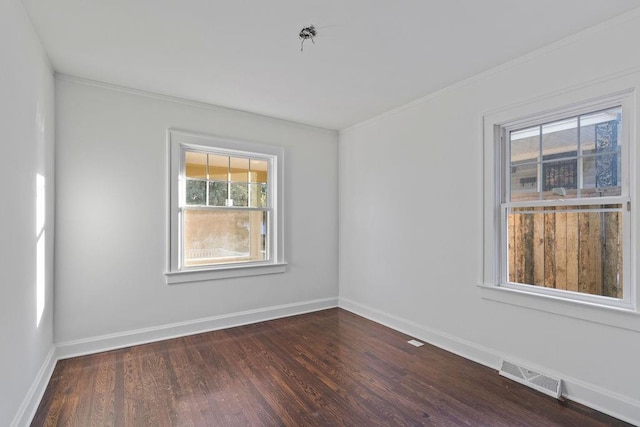 unfurnished room featuring ornamental molding and dark wood-type flooring