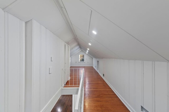 bonus room featuring wood walls, lofted ceiling, and dark hardwood / wood-style flooring