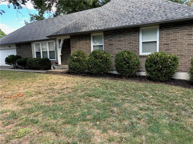 single story home featuring a garage and a front yard