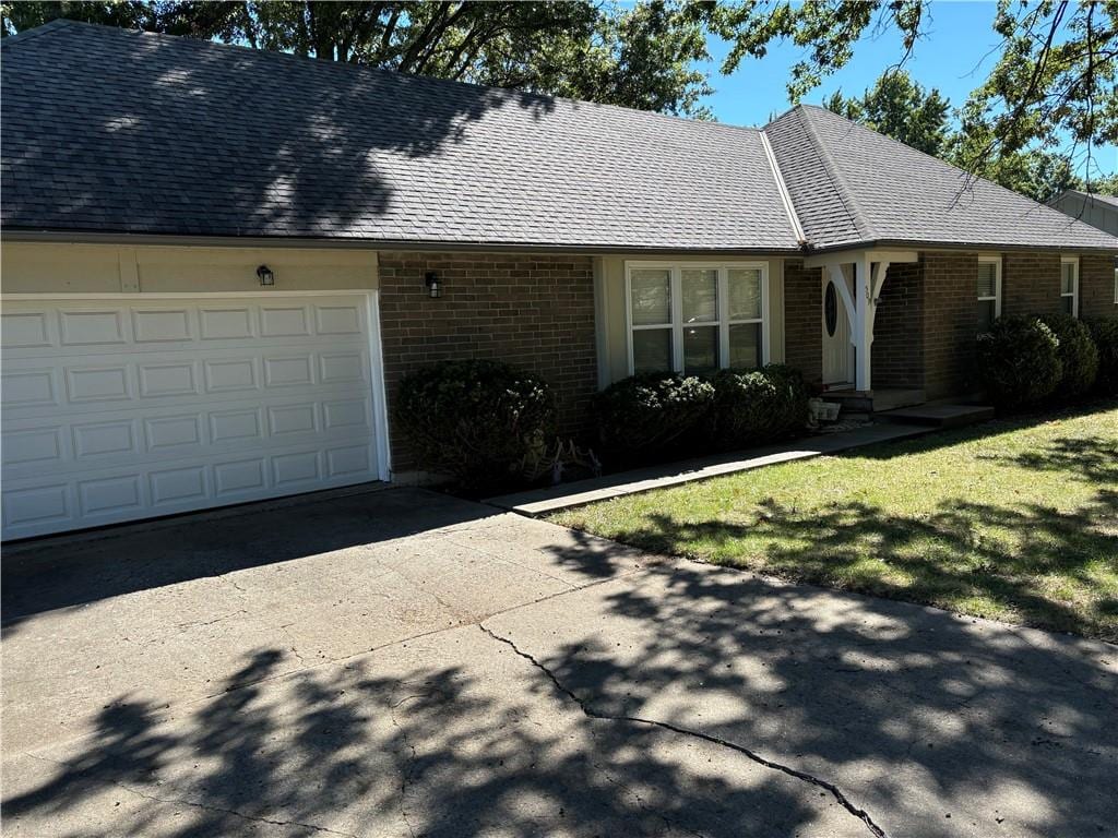 ranch-style home featuring a front yard and a garage