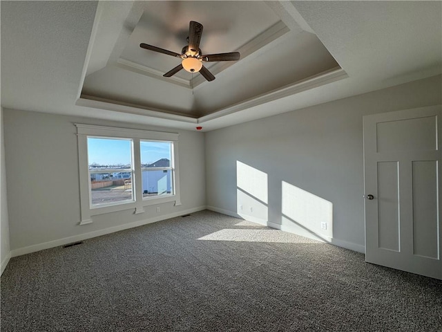 spare room featuring ceiling fan, a raised ceiling, and carpet floors