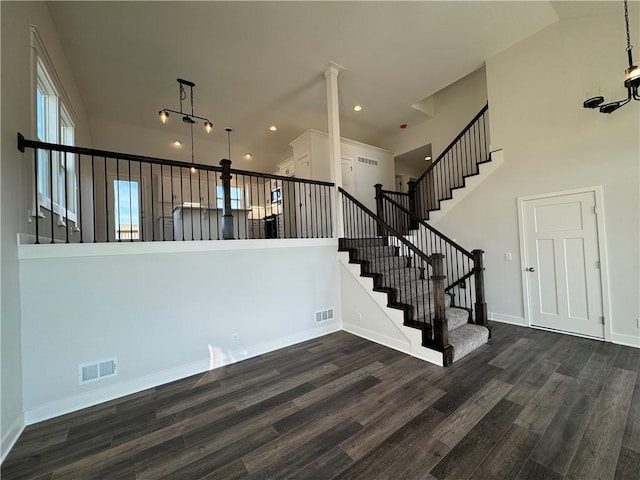 stairway featuring a high ceiling, wood finished floors, baseboards, and recessed lighting