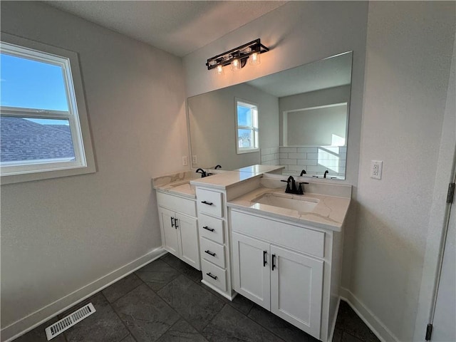 bathroom featuring baseboards, two vanities, and tile patterned flooring