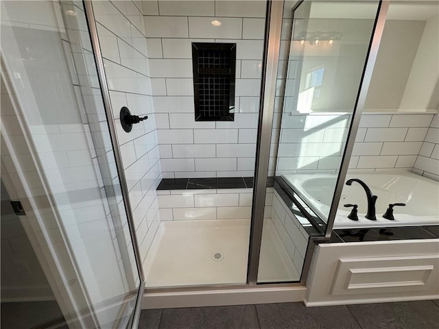 full bath featuring a stall shower, a garden tub, and tile patterned flooring