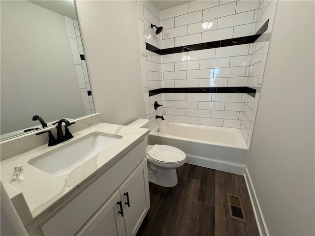 full bathroom featuring toilet, wood finished floors, tub / shower combination, vanity, and baseboards