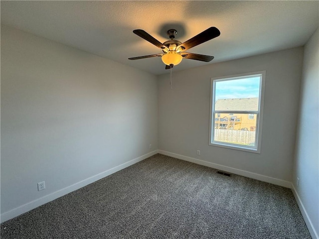 spare room with carpet, a ceiling fan, and baseboards