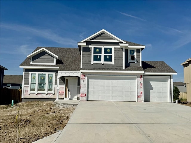 view of front of house featuring concrete driveway, a garage, a shingled roof, and fence
