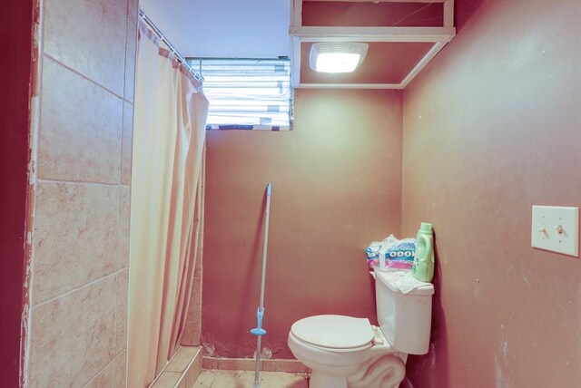 bathroom featuring toilet and a shower with shower curtain