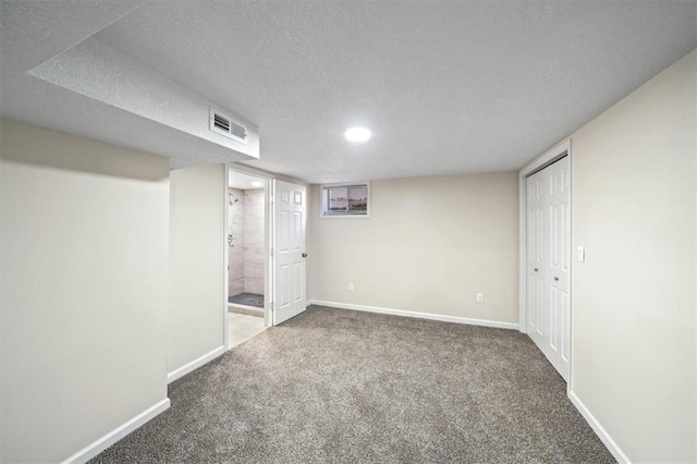 basement featuring carpet floors and a textured ceiling