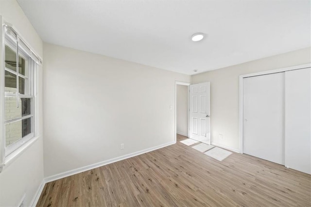 unfurnished bedroom featuring light hardwood / wood-style floors and a closet