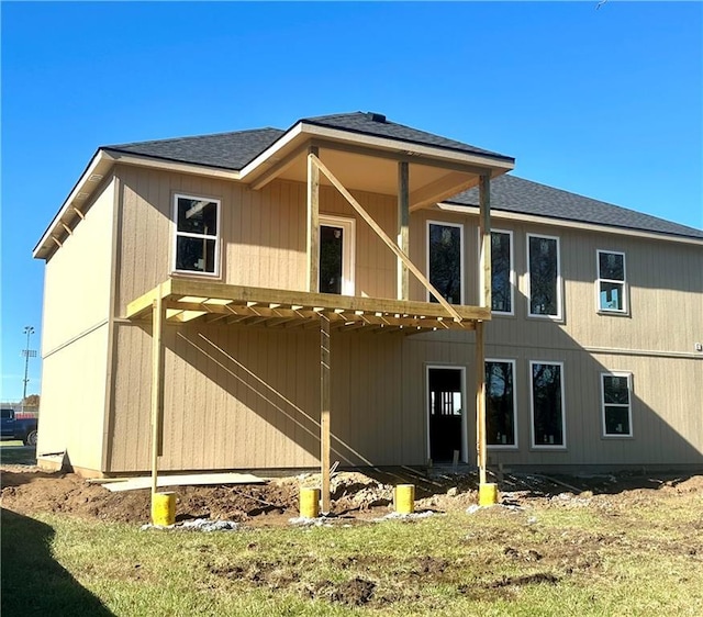 rear view of house featuring roof with shingles