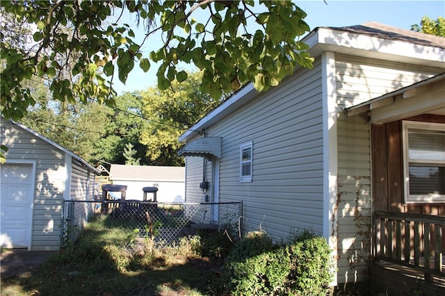 view of property exterior with an outdoor structure and a garage