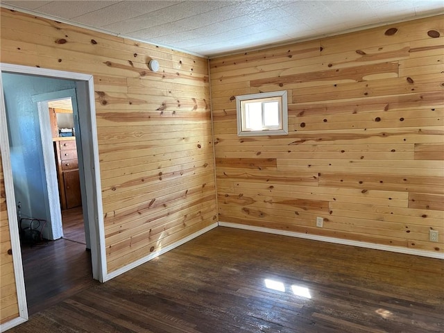 empty room with wood walls and dark hardwood / wood-style floors