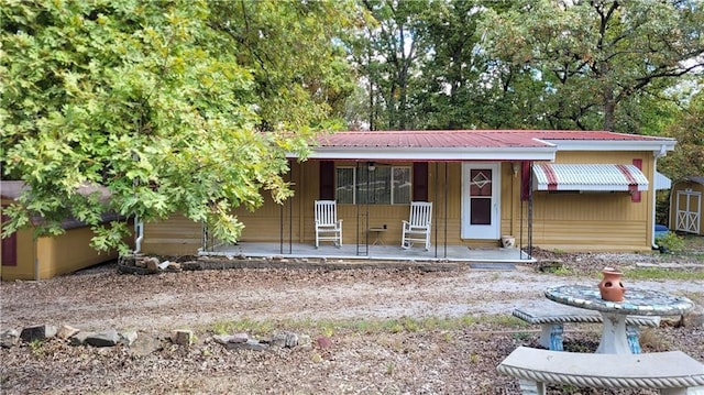 28530 Shore Rd, Warsaw, MO 65355 - view of front of house featuring covered porch, a metal roof, and a shed