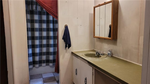 bathroom with a shower with shower curtain, tile patterned floors, and vanity