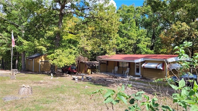28530 Shore Rd, Warsaw, MO 65355 - back of property featuring a detached garage, a storage unit, covered porch, and a lawn