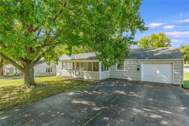 ranch-style house featuring a front lawn and a garage