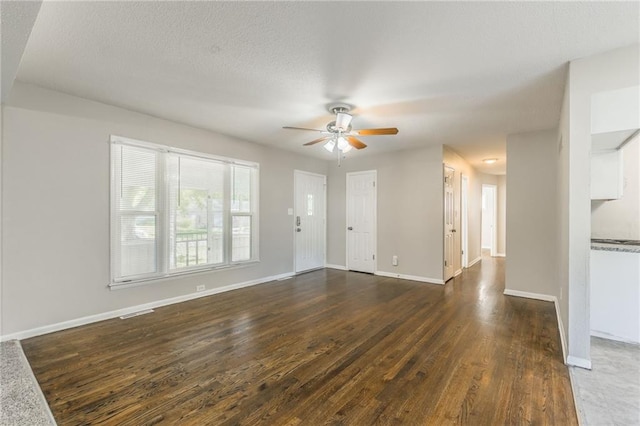 unfurnished living room featuring ceiling fan, a textured ceiling, and dark hardwood / wood-style flooring