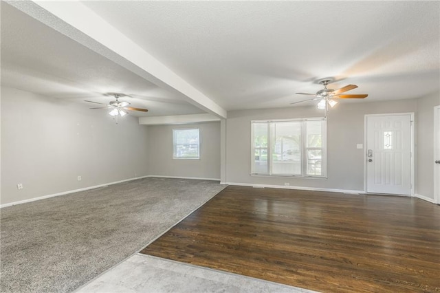 unfurnished living room with ceiling fan, beam ceiling, and dark hardwood / wood-style flooring