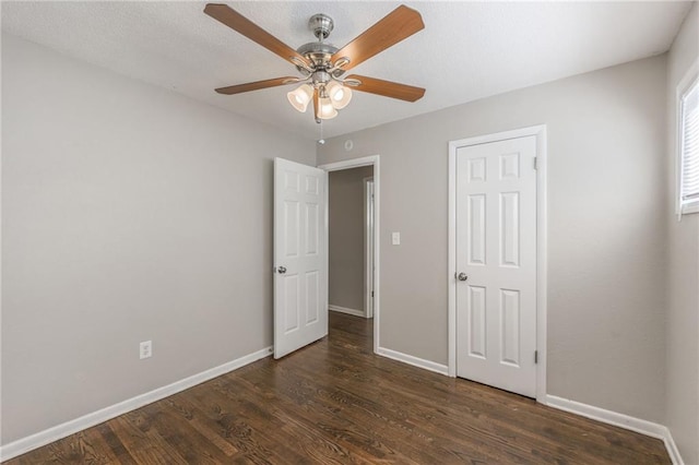 unfurnished bedroom with ceiling fan and dark hardwood / wood-style flooring