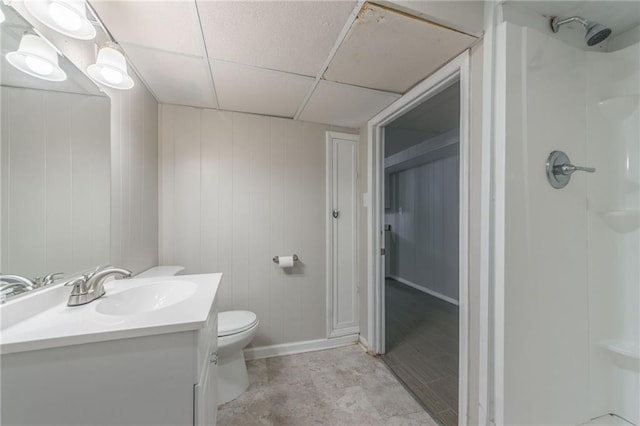 bathroom with walk in shower, wooden walls, vanity, and toilet