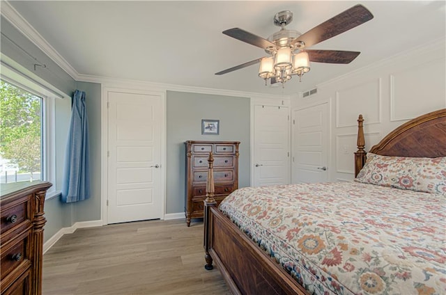 bedroom with crown molding, ceiling fan, and light wood-type flooring