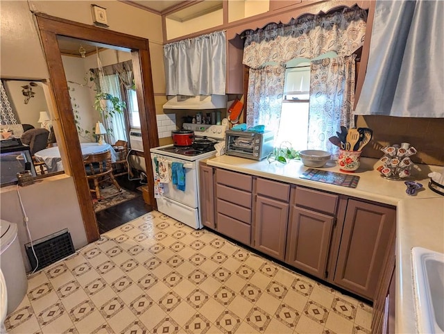 kitchen with ventilation hood, sink, white range, and light wood-type flooring