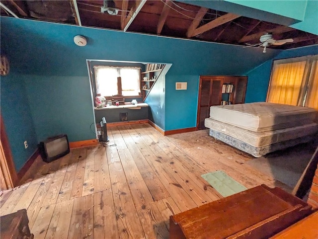 bedroom with vaulted ceiling with beams and wood-type flooring