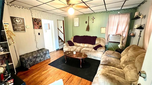 living room with a paneled ceiling, ceiling fan, and hardwood / wood-style flooring