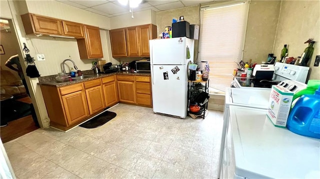 kitchen featuring a drop ceiling, sink, and white appliances