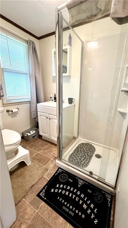 bathroom featuring crown molding, tile patterned floors, a shower with shower door, vanity, and toilet