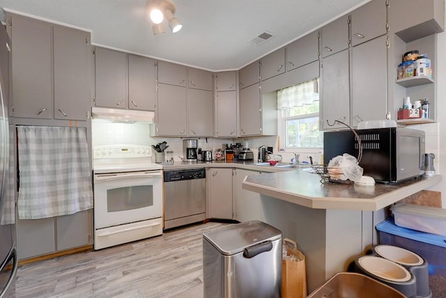 kitchen with white range with electric stovetop, a peninsula, gray cabinetry, under cabinet range hood, and stainless steel dishwasher