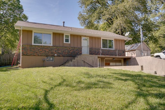 view of front of property featuring brick siding, board and batten siding, a front yard, and fence