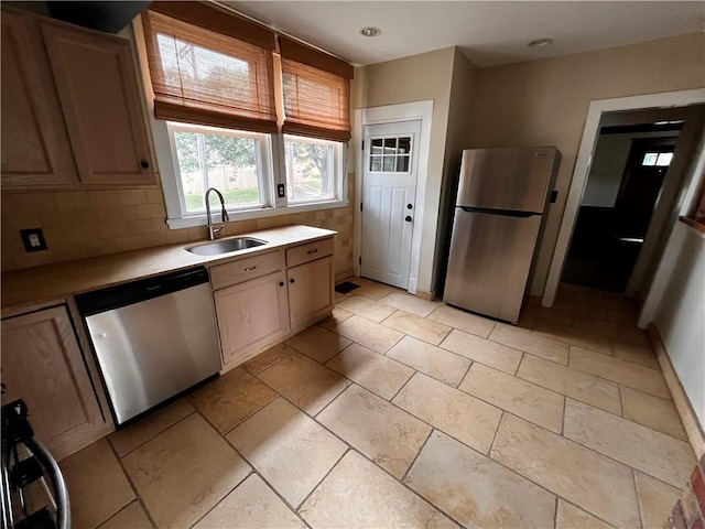 kitchen with light brown cabinetry, appliances with stainless steel finishes, sink, and tasteful backsplash