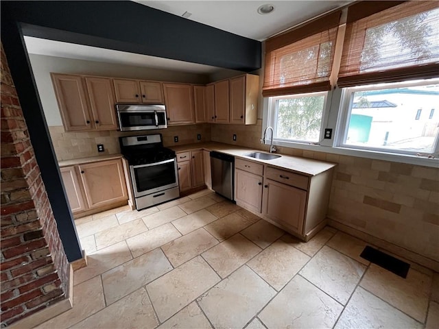 kitchen with backsplash, light brown cabinets, appliances with stainless steel finishes, and sink