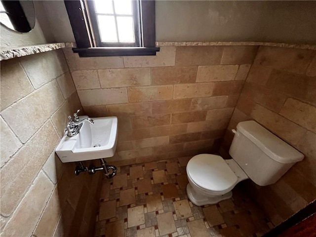 bathroom with tile walls, sink, and toilet