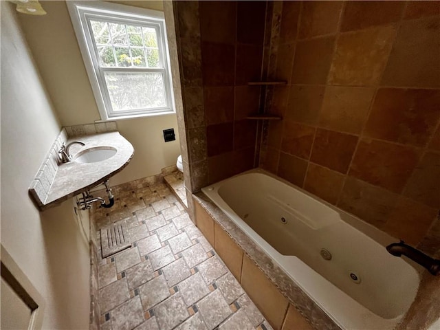 bathroom featuring tiled tub and toilet