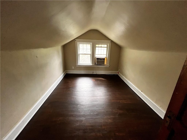 bonus room featuring cooling unit, vaulted ceiling, and dark wood-type flooring