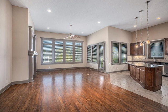 kitchen featuring ceiling fan, a kitchen island, plenty of natural light, and light hardwood / wood-style floors