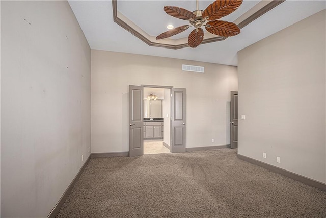 unfurnished bedroom with a raised ceiling, carpet flooring, and ceiling fan