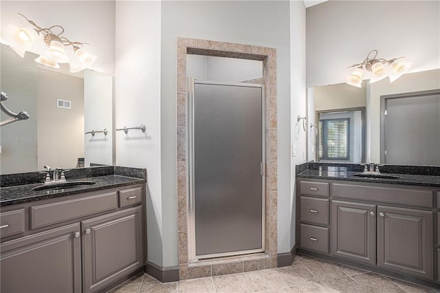 bathroom with tile patterned flooring, an enclosed shower, and vanity