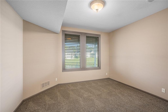 carpeted empty room featuring a textured ceiling