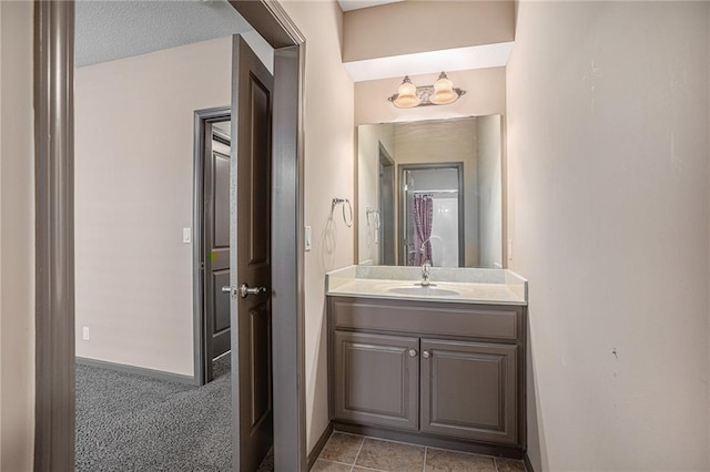 bathroom featuring tile patterned flooring, vanity, and a textured ceiling