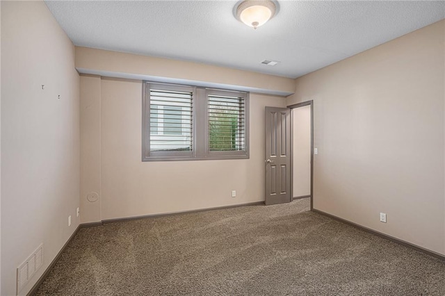 spare room with carpet and a textured ceiling