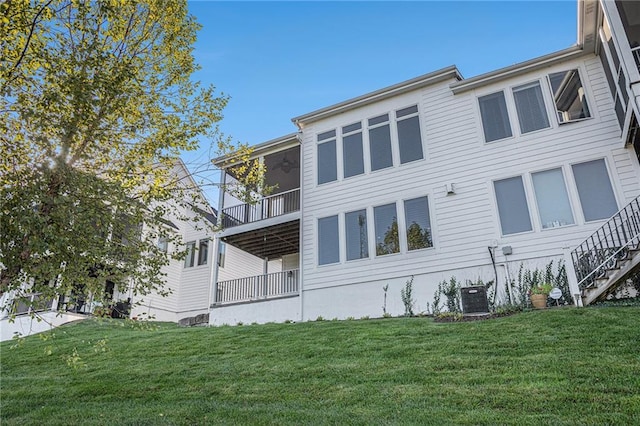 rear view of property with a yard and central AC unit