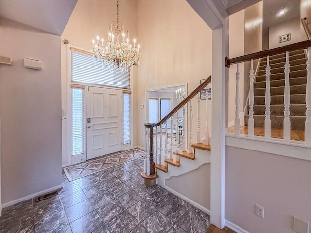 foyer with a towering ceiling and an inviting chandelier