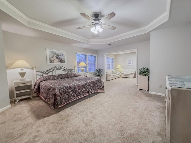 carpeted bedroom featuring ceiling fan, a raised ceiling, and crown molding