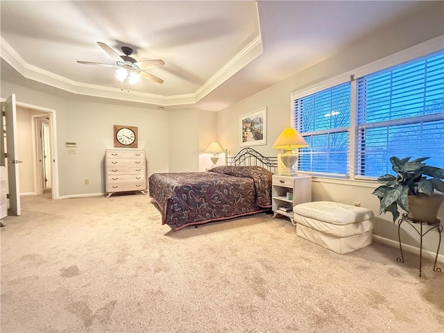 carpeted bedroom featuring a tray ceiling, ceiling fan, and crown molding